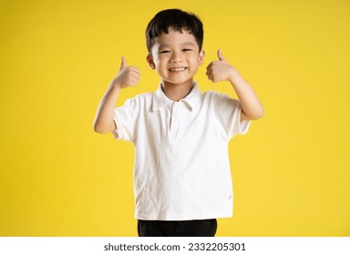 image of asian boy posing on a yellow background
 - Shutterstock ID 2332205301