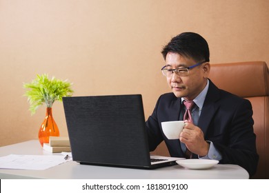 Image Of Asian Business Man Using Laptop While Sitting In Office