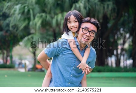 Image of Asian father and daughter playing together at park
