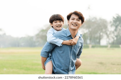 image of an asian father and son having fun in the park - Powered by Shutterstock