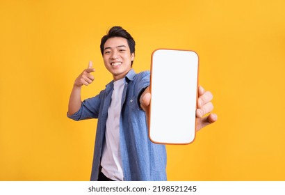 image of asian man holding phone, isolated on yellow background - Shutterstock ID 2198521245