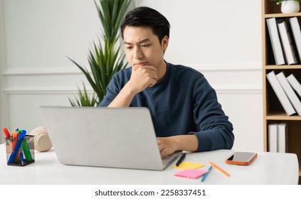 image of Asian man sitting at home working - Powered by Shutterstock