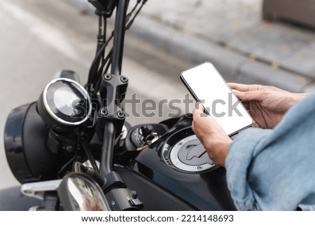 image of asian man, sitting on moto using mobile phone