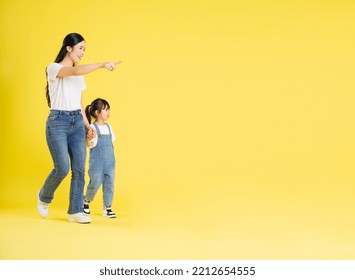 image of asian mother and daughter posing on a yellow background - Powered by Shutterstock