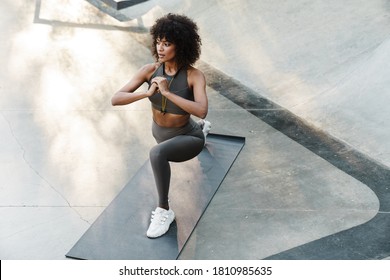 Image of athletic african american sportswoman doing exercise while working out on sports ground - Powered by Shutterstock