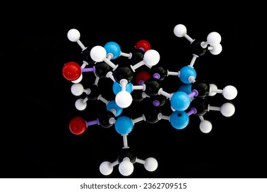 Image of atomic structure model of caffeine with blurred mirror reflection and black background