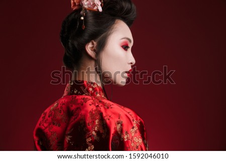Image of attractive asian geisha woman in traditional japanese kimono isolated over red background