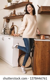 Image Of Attractive Brunette Woman 30s Brewing Coffee In Stainless Steel Turkish Coffee Pot On Plate In Kitchen