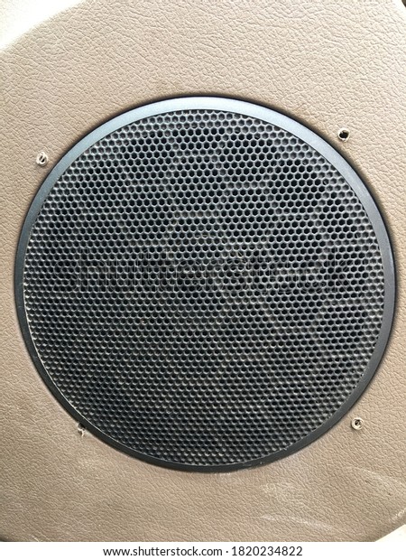 Image of audio\
speaker from an old car\
closeup