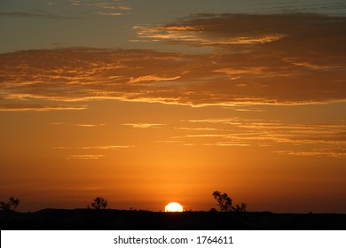 An Image Of The Australian Outback Landscape During A Sunset.