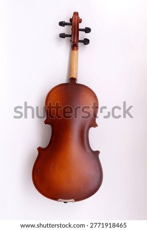 Image of back side of a violin, a string instrument typically used in classical and folk music on black background. 
