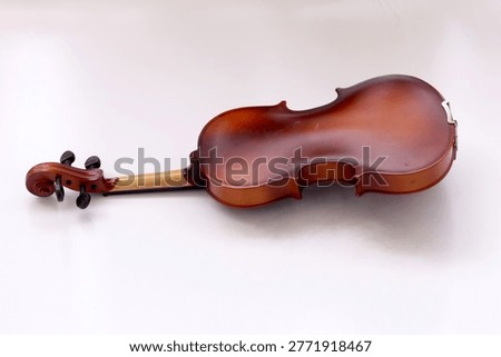 Image of back side of a violin, a string instrument typically used in classical and folk music on black background. 