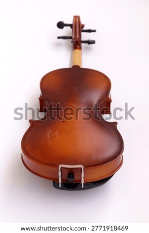 Image of back side of a violin, a string instrument typically used in classical and folk music on black background. 