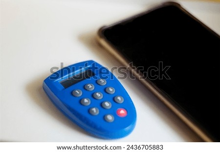 Image of the banking token and smartphone isolated on white background. With selective focus.