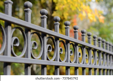 Image of a Beautiful decorative cast iron wrought fence with artistic forging. Metal guardrail close up.