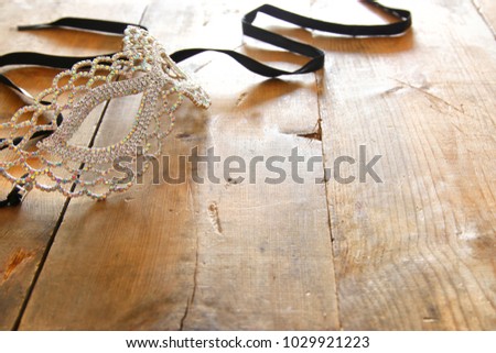 image of beautiful diamond masquerade venetian mask over wooden vintage background