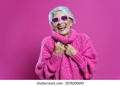 image of a beautiful and elegant old influencer woman. Cool grandmother posing in studio wearing fashionable clothes. Happy senior lady celebrating and making party. Concept about seniority 