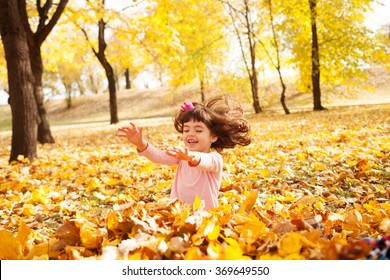 Image Of Beautiful Girl Jumping In The Pile Of Autumn Leaves, Shallow Depth Of Field