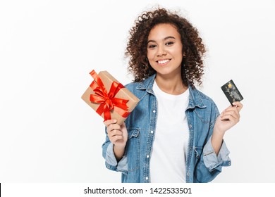 Image Of A Beautiful Happy Young African Woman Posing Isolated Over White Wall Background Holding Present Gift Box And Credit Card.