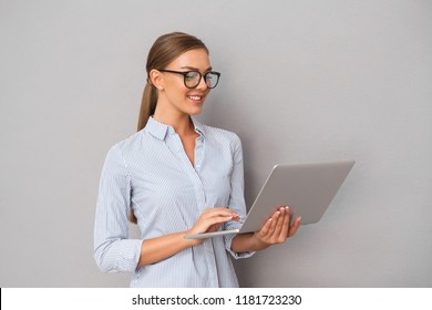 Image Of Beautiful Smiling Business Woman Standing Over Grey Wall Background Using Laptop Computer.