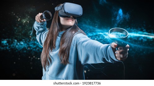 Image of a beautiful stylish woman wearing VR glasses and holding joysticks. Virtual reality concept. Mixed media - Powered by Shutterstock