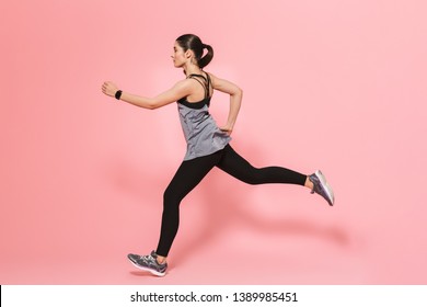 Image Of Beautiful Young Pretty Fitness Woman Running Make Sport Exercises Isolated Over Pink Wall Background.