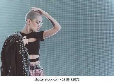 Image Of A Beautiful Young Woman Posing Against A Led Panel. Shaved Head Teenager With Alternative Look Making Urban Portraits