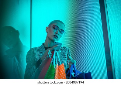 Image Of A Beautiful Young Woman Posing Against A Led Panel. Shaved Head Teenager With Alternative Look Making Urban Portraits