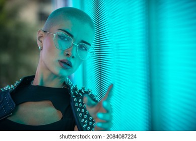 Image Of A Beautiful Young Woman Posing Against A Led Panel. Shaved Head Teenager With Alternative Look Making Urban Portraits