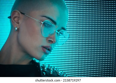 Image Of A Beautiful Young Woman Posing Against A Led Panel. Shaved Head Teenager With Alternative Look Making Urban Portraits