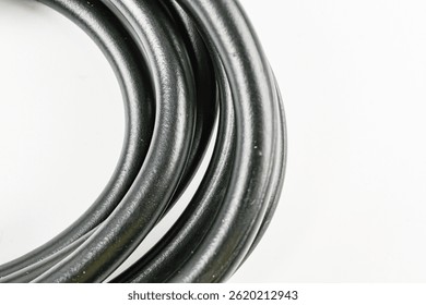 Image of a black coiled cable bundle, resembling a roll or spool New, smooth texture possibly rubberplastic Focused product photography in marketing context for reliable and durable cables