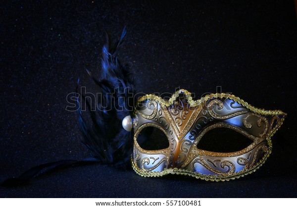 Image of black elegant venetian mask on\
glitter background