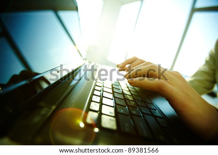 Image of black laptop keyboard with female hands over it