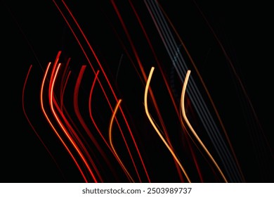 The image is a black and white photo of a car with red and yellow streaks. The streaks are in the form of lines and they are very long. The photo has a very dynamic and energetic feel to it