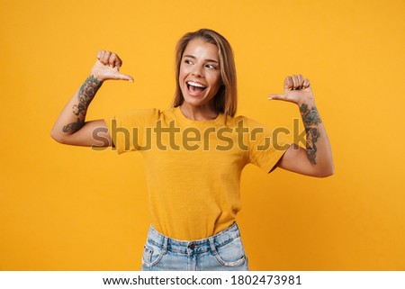 Image of blonde excited woman pointing fingers at herself isolated over yellow background