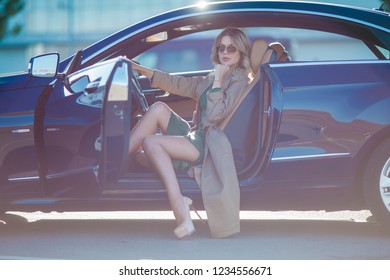 Image Of Blonde With Glasses And Long Dress And High Heels Shoes Sitting In Car With Open Door