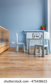 Image Of Blue Baby Room With Floor Panels, Cot, Small Chairs, Table And Heater