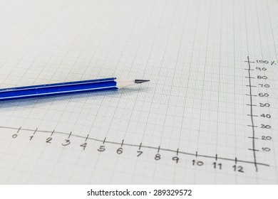 An Image Of Blue And Black Color Pencils On Graph Paper, Selective Focus To Blue Pencil