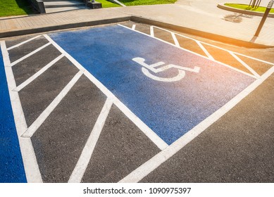 image of blue new handicapped symbol shows sign reserved for disability person on car parking space.