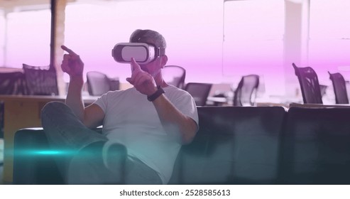 Image of blue and pink light trails moving over caucasian man wearing vr headset at office. Futuristic business technology concept - Powered by Shutterstock