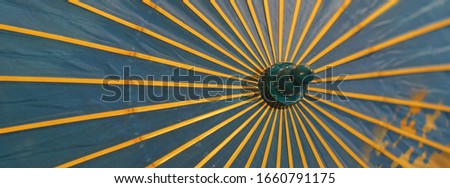 Image of a blue umbrella with yellow spokes that protects from the sun. 1930-1940 in Russia. Suitable as background, template, touristic guide, poster, greating card. Protection against sun concepts