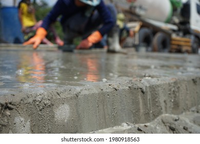 The image is blurred, the workers pouring concrete. In the construction of the island in the middle of the road