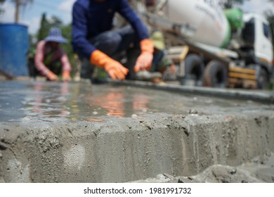 The image is blurred, the workers pouring concrete. In the construction of the island in the middle of the road