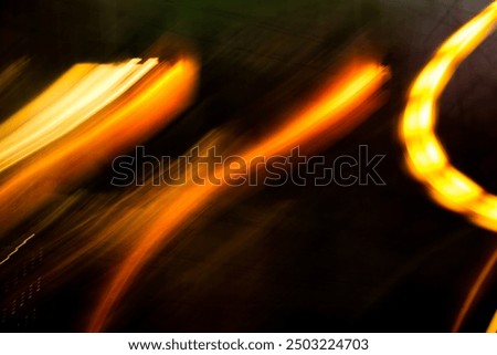 The image is a blurry, abstract representation of flames. The flames are orange and appear to be moving in a circular motion. Scene is one of energy and movement