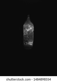 An image of a bottle in which light is trapped and surrounded by a dark background provokes the thought process of viewers inorder to relate to it