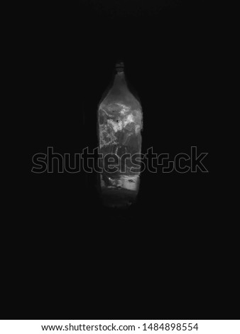 An image of a bottle in which light is trapped and surrounded by a dark background provokes the thought process of viewers inorder to relate to it