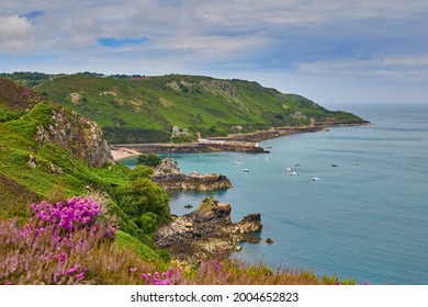 Image of Bouley Bay from adjacent cliff paths. with cloudy sky and calm sea. Jersey, Channel Islands. Selective focus.