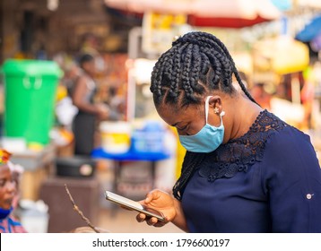 Image Of Braided African Lady With Face Mask, Surfing With Smart Phone-African Market Scene