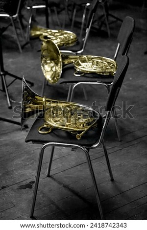Image of a brass musical instrument horn lying on a chair