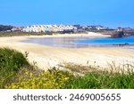 Image of Braye Beach, Alderney, Channel Islands, with Braye Harbour in the background.